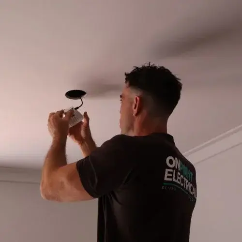 Licensed electrician installing an LED downlight in a residential property in Woodlands WA.