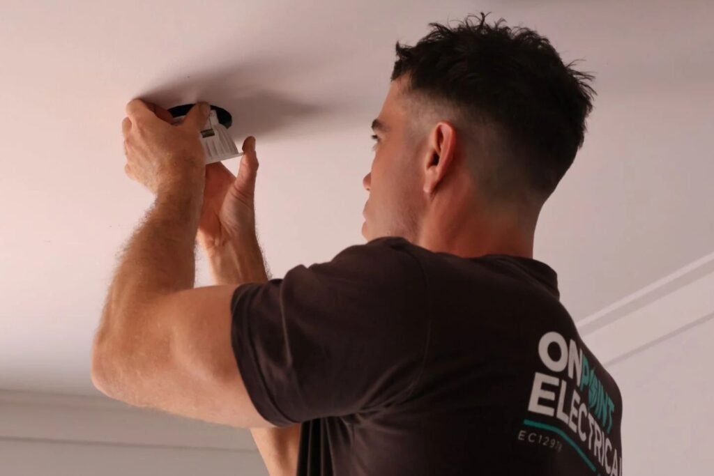 Electrician installing a photoelectric smoke alarm in a Perth home